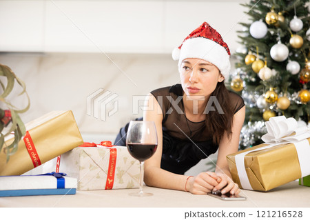 upset young girl in santa hat sits in kitchen. 121216528