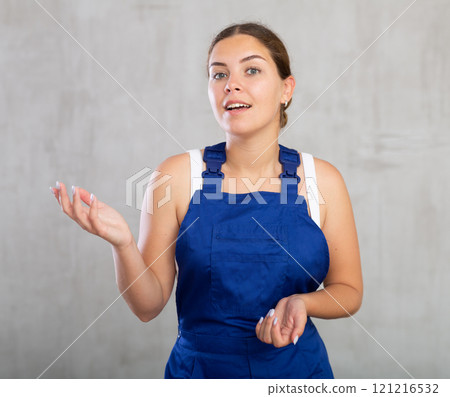 Young woman posing in work overalls in studio 121216532