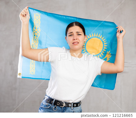 Irritated girl stands with flag of Kazakhstan. Isolated on gray background Irritated girl stands with flag of Kazakhstan. Isolated on gray background 121216665