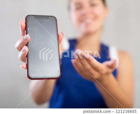 Young woman in work overalls posing with phone Young woman in work overalls posing with phone 121216685