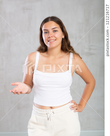 Happy young woman in casual clothes showing something with her hands Happy young woman in casual clothes showing something with her hands 121216717
