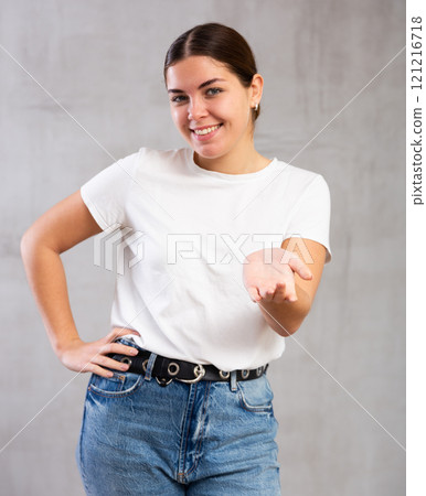 Smiling young woman in casual clothes gesturing Smiling young woman in casual clothes gesturing 121216718