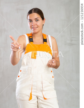 Portrait of happy emotional female builder or mechanic in overalls 121216934