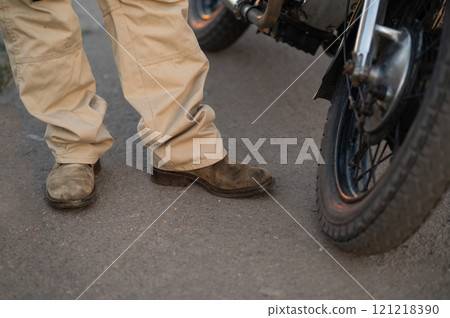 a biker near a motorcycle. biker boots 121218390