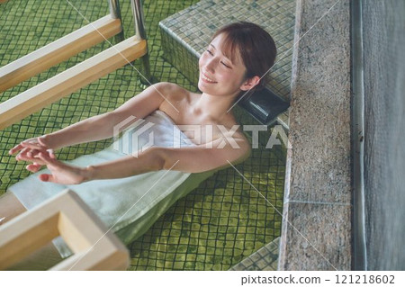 A young woman relaxing in an open-air bath. Photo courtesy of Shiratama no Yu Izumi Kei 121218602