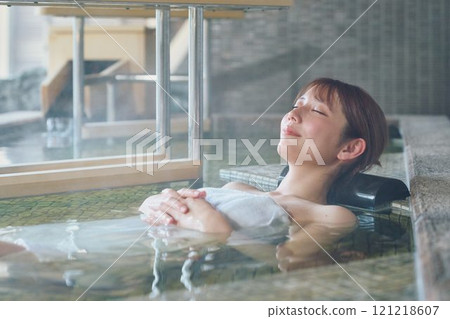 A young woman relaxing in an open-air bath. Photo courtesy of Shiratama no Yu Izumi Kei 121218607