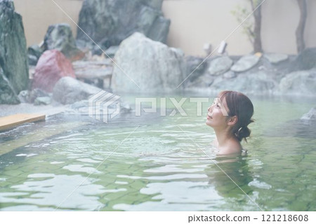 A young woman relaxing in an open-air bath. Photo courtesy of Shiratama no Yu Izumi Kei 121218608