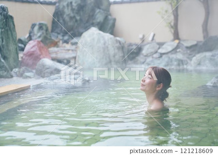A young woman relaxing in an open-air bath. Photo courtesy of Shiratama no Yu Izumi Kei 121218609