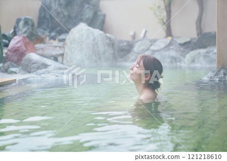 一位年輕女子在露天浴池中放鬆 攝影由 Izukei Shiratama-no-yu 提供。 121218610