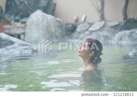 A young woman relaxing in an open-air bath. Photo courtesy of Shiratama no Yu Izumi Kei 121218611