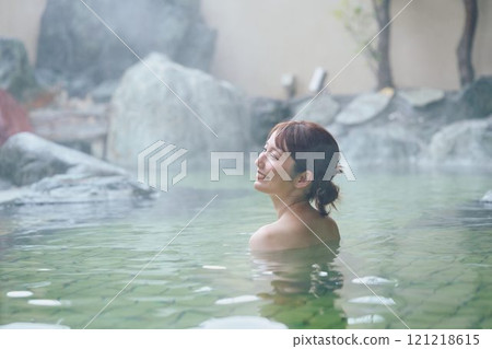A young woman relaxing in an open-air bath. Photo courtesy of Shiratama no Yu Izumi Kei 121218615
