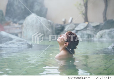 A young woman relaxing in an open-air bath. Photo courtesy of Shiratama no Yu Izumi Kei 121218616