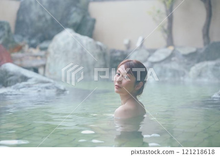 一位年輕女子在露天浴池中放鬆 攝影由 Izukei Shiratama-no-yu 提供。 一位年輕女子在露天浴池中放鬆 攝影由 Izukei Shiratama-no-yu 提供。 121218618