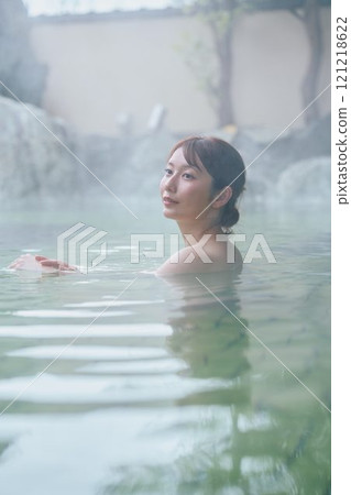 一位年輕女子在露天浴池中放鬆 攝影由 Izukei Shiratama-no-yu 提供。 121218622