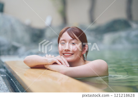 A young woman relaxing in an open-air bath. Photo courtesy of Shiratama no Yu Izumi Kei 121218628