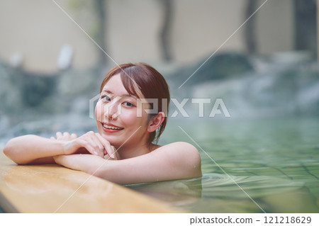 一位年輕女子在露天浴池中放鬆 攝影由 Izukei Shiratama-no-yu 提供。 121218629