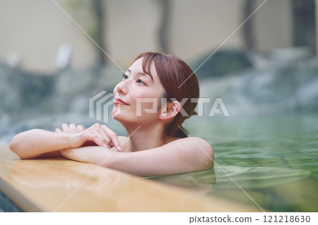 A young woman relaxing in an open-air bath. Photo courtesy of Shiratama no Yu Izumi Kei 121218630