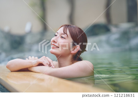 一位年輕女子在露天浴池中放鬆 攝影由 Izukei Shiratama-no-yu 提供。 121218631