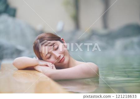 A young woman relaxing in an open-air bath. Photo courtesy of Shiratama no Yu Izumi Kei 121218633