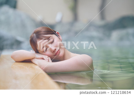 A young woman relaxing in an open-air bath. Photo courtesy of Shiratama no Yu Izumi Kei 121218634