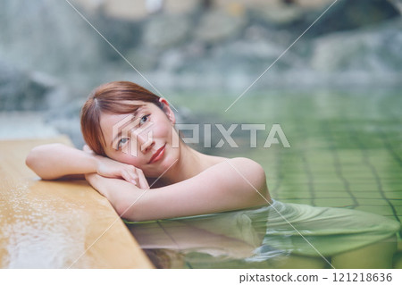 A young woman relaxing in an open-air bath. Photo courtesy of Shiratama no Yu Izumi Kei 121218636