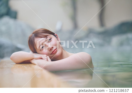 A young woman relaxing in an open-air bath. Photo courtesy of Shiratama no Yu Izumi Kei 121218637
