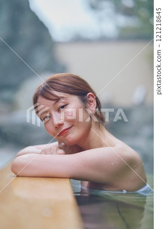 A young woman relaxing in an open-air bath. Photo courtesy of Shiratama no Yu Izumi Kei 121218645