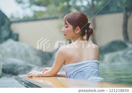 A young woman relaxing in an open-air bath. Photo courtesy of Shiratama no Yu Izumi Kei 121218650
