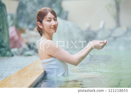 A young woman relaxing in an open-air bath. Photo courtesy of Shiratama no Yu Izumi Kei 121218655