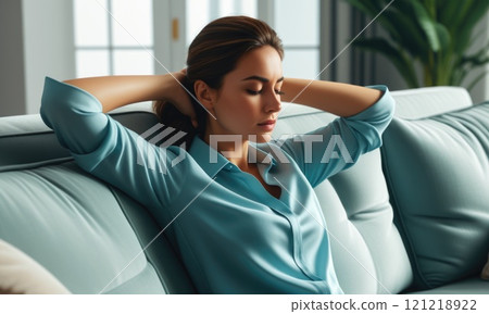 Woman relaxing on couch in blue shirt, enjoying calm moment at home Woman relaxing on couch in blue shirt, enjoying calm moment at home 121218922