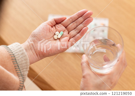 The hands of middle-aged to senior women taking regular medication 121219050