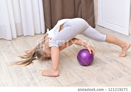 A little girl plays with a ball in an apartment A little girl plays with a ball in an apartment 121219271