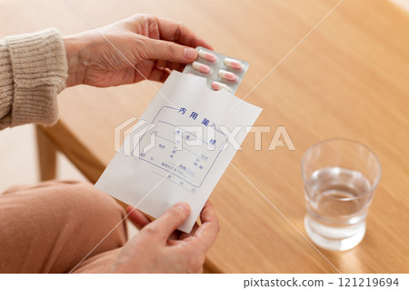 The hands of middle-aged to senior women taking regular medication 121219694