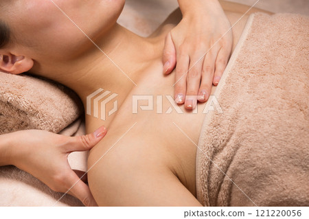 一位年輕的亞洲女性正在接受肩部按摩。 121220056