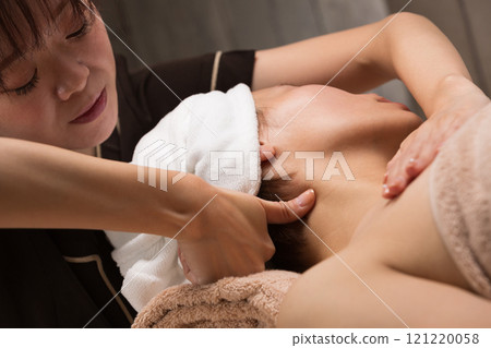 Young asian beautician doing neck massage. 121220058