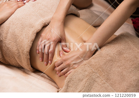 Young Asian woman getting a belly oil massage. 121220059