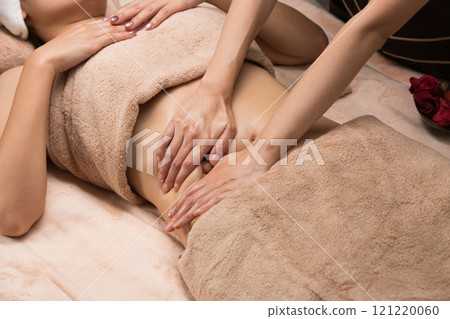Young Asian woman getting a belly oil massage. 121220060