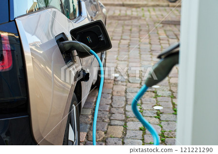 Electric car charging at public charging station 121221290