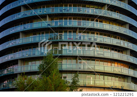 Modern round building with curved glass facade 121221291