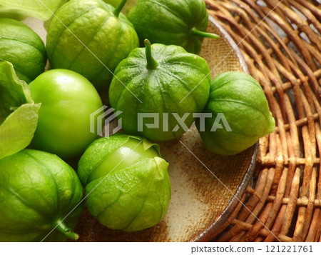 Harvested green tomatillos on a basket and plate Harvested green tomatillos on a basket and plate 121221761
