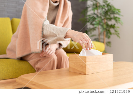 冬季房間裡拿著紙巾的中高級婦女 冬季房間裡拿著紙巾的中高級婦女 121221939