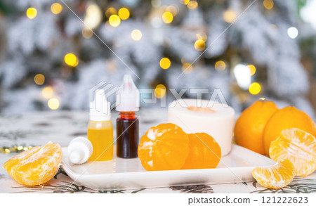 Handmade soap in the form of Orange tangerine with bottles of dye, flavor, a block of glycerin soap base, silicone mold, on background of Christmas tree with golden light. Soap as gift new year Handmade soap in the form of Orange tangerine with bottles of dye, flavor, a block of glycerin soap base, silicone mold, on background of Christmas tree with golden light. Soap as gift new year 121222623