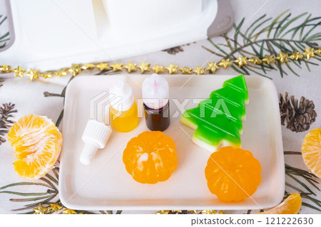 Handmade soap in the form of Orange tangerine And a green Christmas tree with bottles of dye, flavor, a block of glycerin soap base, silicone mold, pipette. Soap as a gift, home-made 121222630
