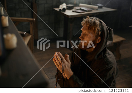 Desperate priest kneeling before church altar in mystical smoke Desperate priest kneeling before church altar in mystical smoke 121223521