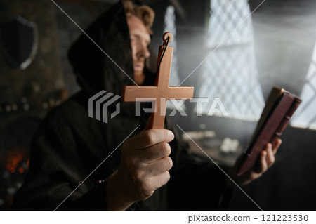 Priest holding cross and holy bible performing exorcism rite 121223530