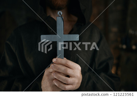 Silver cross in medieval monk hands 121223561