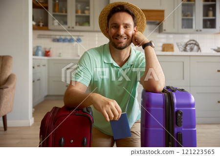 Portrait of happy man tourist with packed stuff in travel suitcases 121223565
