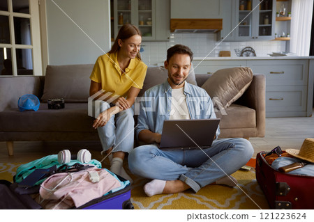 Loving couple booking vacation trip choosing flight on internet via laptop 121223624