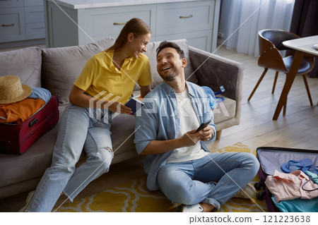 Joyful married couple booking hotel for vacation via mobile phone 121223638