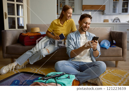 Happy married couple booking hotel for vacation via mobile phone 121223639